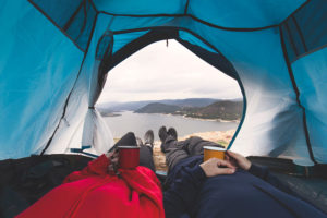 Wanderer auf Feldbett in Zelt