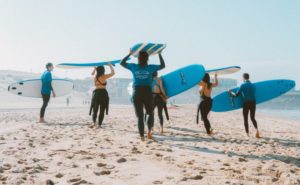 Surfer mit Wetsuits am Strand