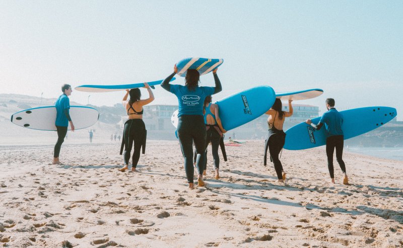 Surfer mit Wetsuits am Strand