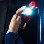Standboxsack Test während des Trainings eines oberkörperfreien Boxers
