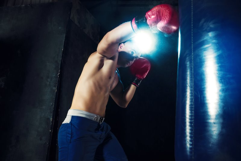 Standboxsack Test während des Trainings eines oberkörperfreien Boxers