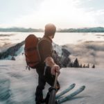 Mann mit Skirucksack im Schnee in den Bergen auf Skiern