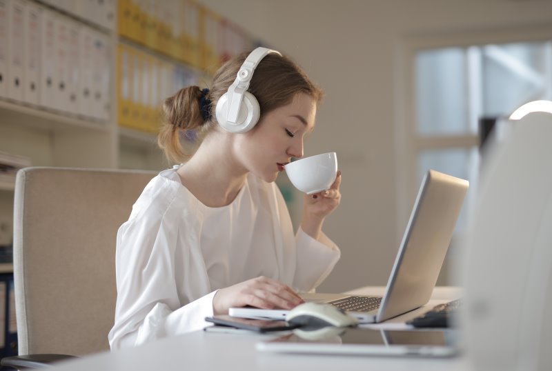 Eine Frau benutzt Bluetooth-Kopfhörer zum Arbeiten