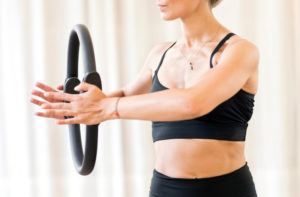 Frau benutzt Pilatesring im Workout