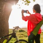 Frau mit Handy und Fahrrad