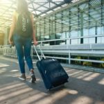 Reisende zieht ihre Reisetasche mit Rollen