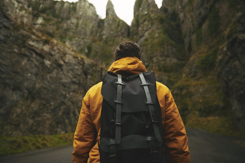 Mann mit Rucksack der mithilfe einer Packliste gefüllt wurde.