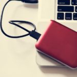 Ein rotes externes DVD Laufwerk auf einem Notebook