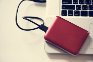 Ein rotes externes DVD Laufwerk auf einem Notebook