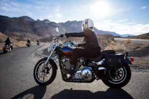Frau fährt Motorrad mit Satteltasche