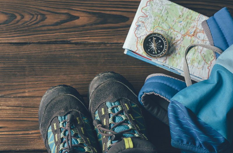 Foto von Wanderschuhe, Wanderrucksack, Kompass und Wanderkarte im Flatlay