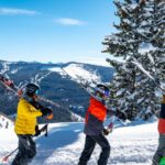 3 Menschen tragen Skier