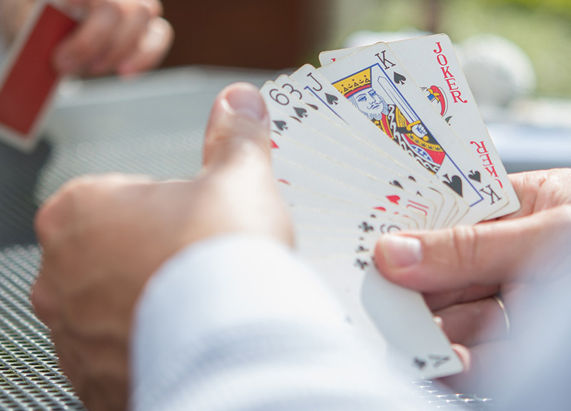 Person hält Mau-Mau-Karten