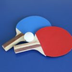 Zwei Tischtennischläger mit einem Tischtennisball