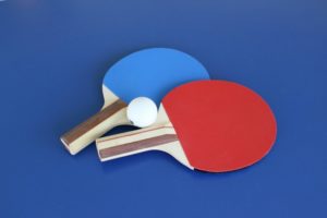 Zwei Tischtennischläger mit einem Tischtennisball