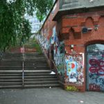 Ein altes Gebäude mit Graffiti in Hamburg mit Treppe zum Crossboule spielen.