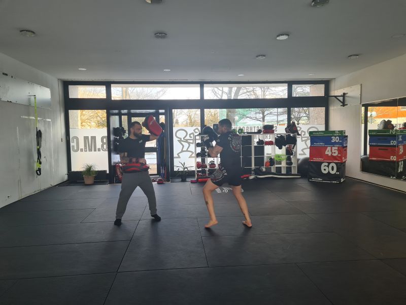Bild eines Trainings im Bavarian MMA Center e.V., bei dem Teilnehmer Kampfkunsttechniken üben.