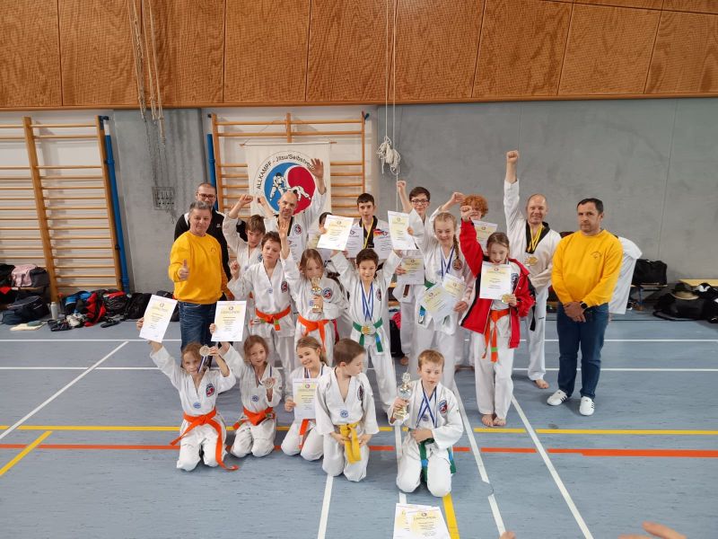 Kinder und Trainer feiern ihre Erfolge bei einem Allkampf-Jitsu-Wettbewerb.