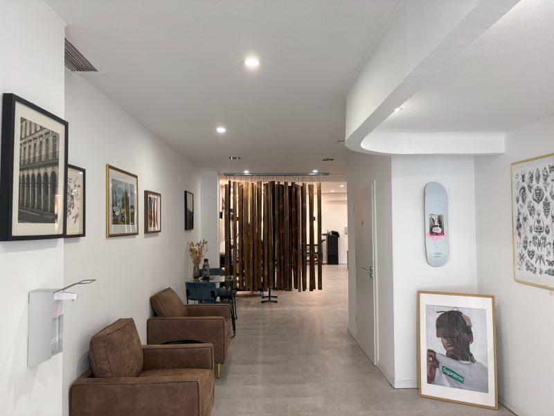 Innenansicht eines Tattoo-Studios mit modernem Design, Holztrennwand und bequemen Sitzgelegenheiten für eine entspannte Atmosphäre.