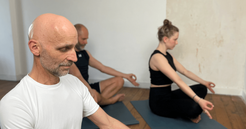 Menschen bei einer Meditation in einem Yogastudio.